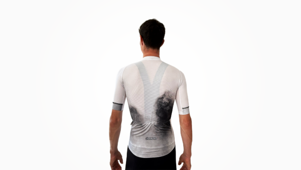Maillot manches courtes blanc et noir, avec détails techniques visibles, porté par un cycliste vu de dos.