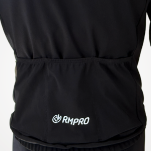 Veste technique noire avec poches arrière, logo RMPRO visible.