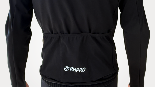 Veste technique noire avec poches arrière, logo RMPRO visible.