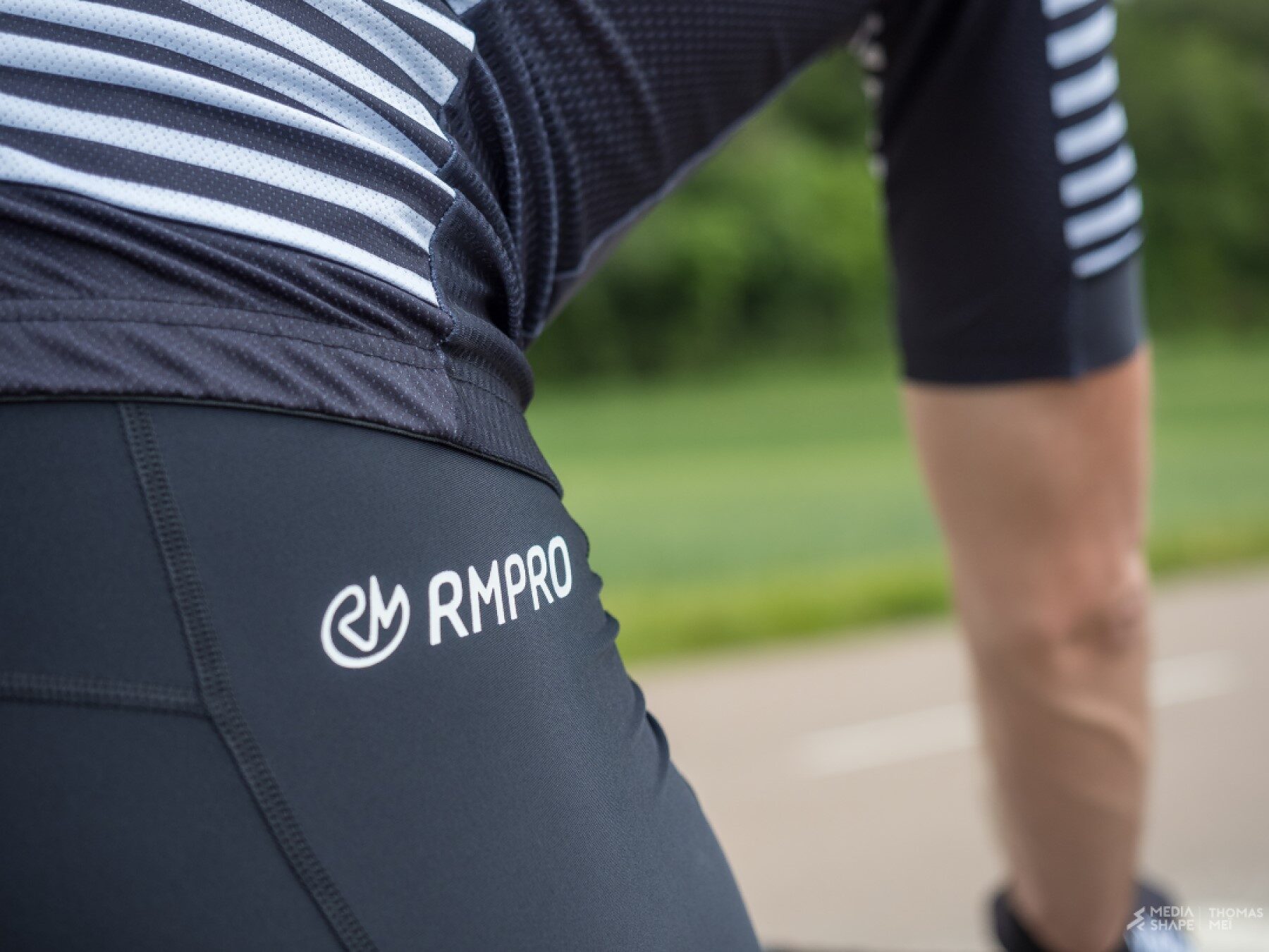 Cycliste en tenue personnalisée bleue levant les bras en signe de victoire devant un public enthousiaste.
