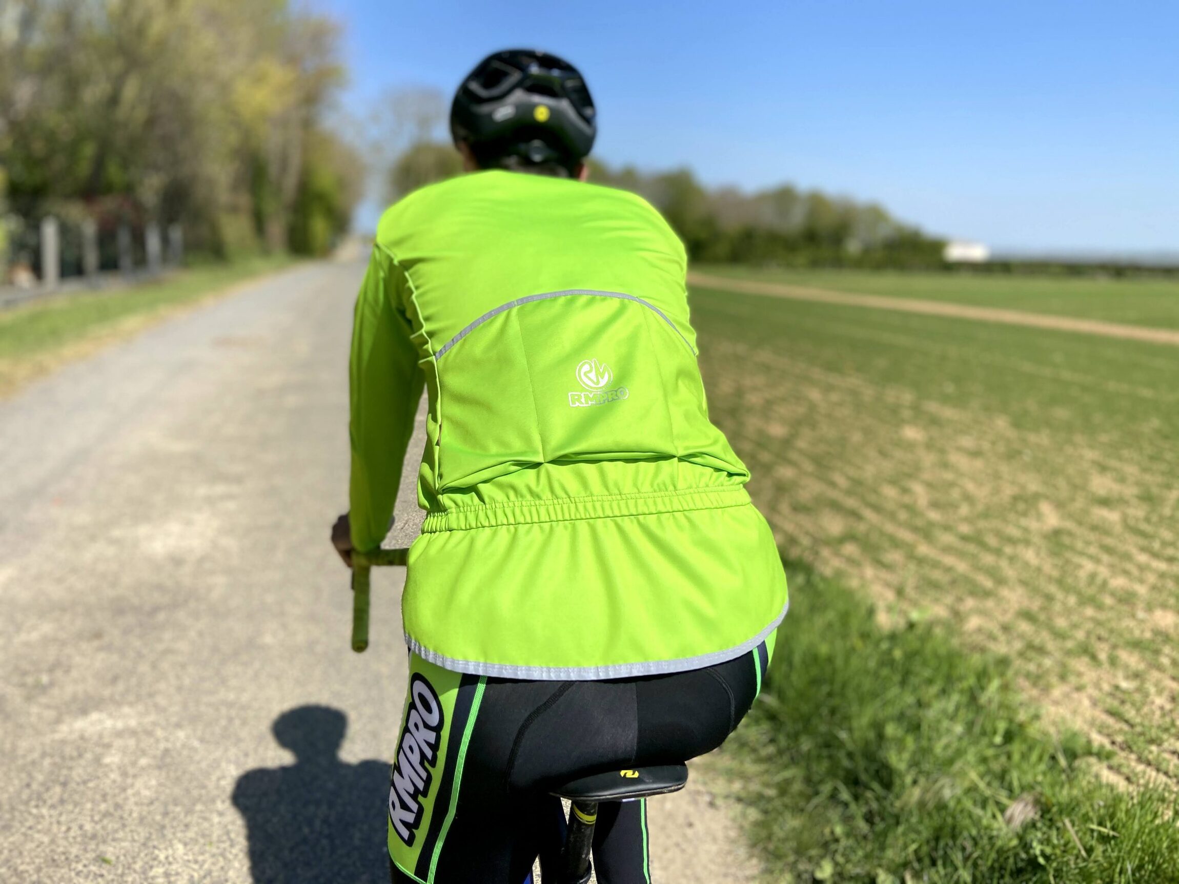 Cycliste en tenue personnalisée bleue levant les bras en signe de victoire devant un public enthousiaste.