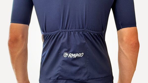 Maillot manches courtes bleu avec logo RMPRO, vue arrière sur silhouette de cycliste.
