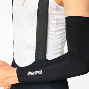 Manchettes noires techniques adaptées pour le cyclisme, portées avec un maillot à bretelles.