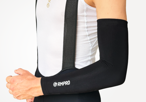 Manchettes noires techniques adaptées pour le cyclisme, portées avec un maillot à bretelles.