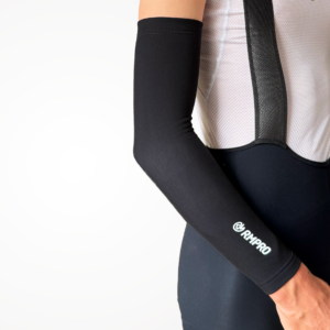 Manchette technique noire portée avec un maillot cycliste à manches courtes.