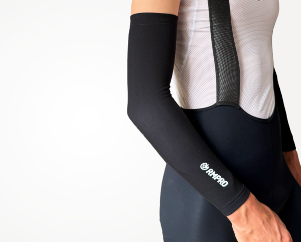 Manchette technique noire portée avec un maillot cycliste à manches courtes.