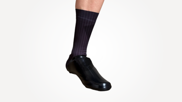 Couvre chaussures aéro noir porté avec des chaussettes techniques, adapté pour le cyclisme.