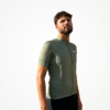 Maillot manches courtes vert olive technique avec zip et logo, porté par un mannequin.