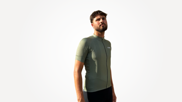 Maillot manches courtes vert olive technique avec zip et logo, porté par un mannequin.