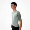 Maillot manches courtes vert clair, coupe ajustée et détails techniques visibles.